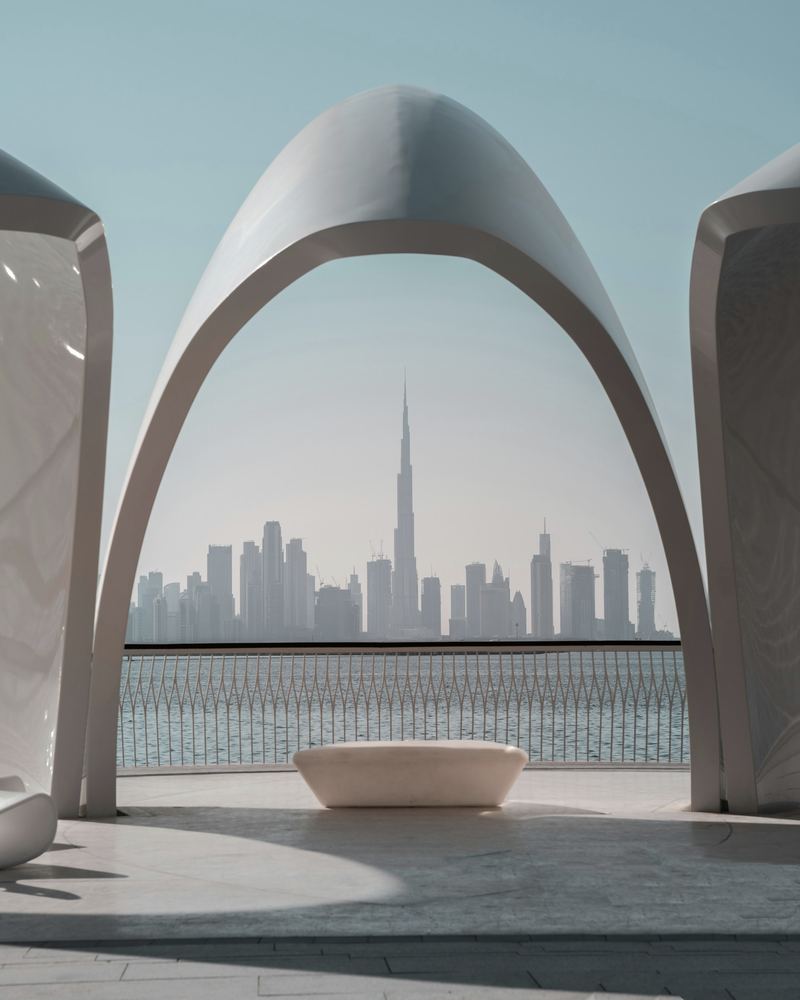 The Dubai skyline seen through a white arch